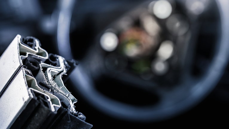 Tampilan dekat profil logam yang baru dipotong dengan serpihan halus di tepinya.