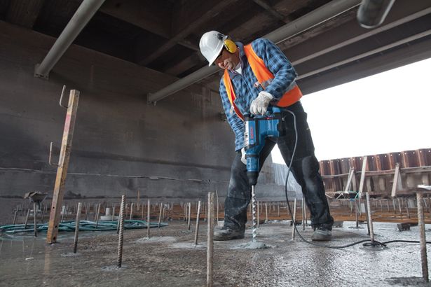 GBH 8-45 DV Seseorang yang mengenakan peralatan keselamatan mengebor beton dengan palu putar.